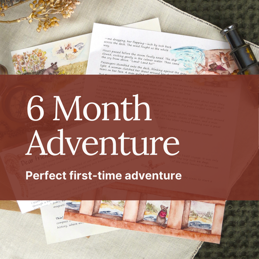 A styled flat-lay of children's book pages and a small black toy camera on a textured fabric surface, with a large translucent maroon banner across the center reading '6 Month Adventure' and 'Perfect first-time adventure.'.